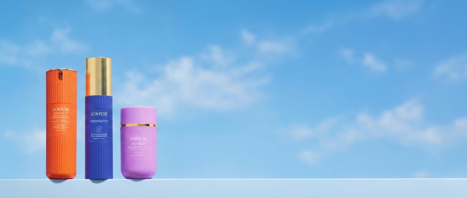 Three Lion Pose bottles in orange, blue and lilac against a blue sky