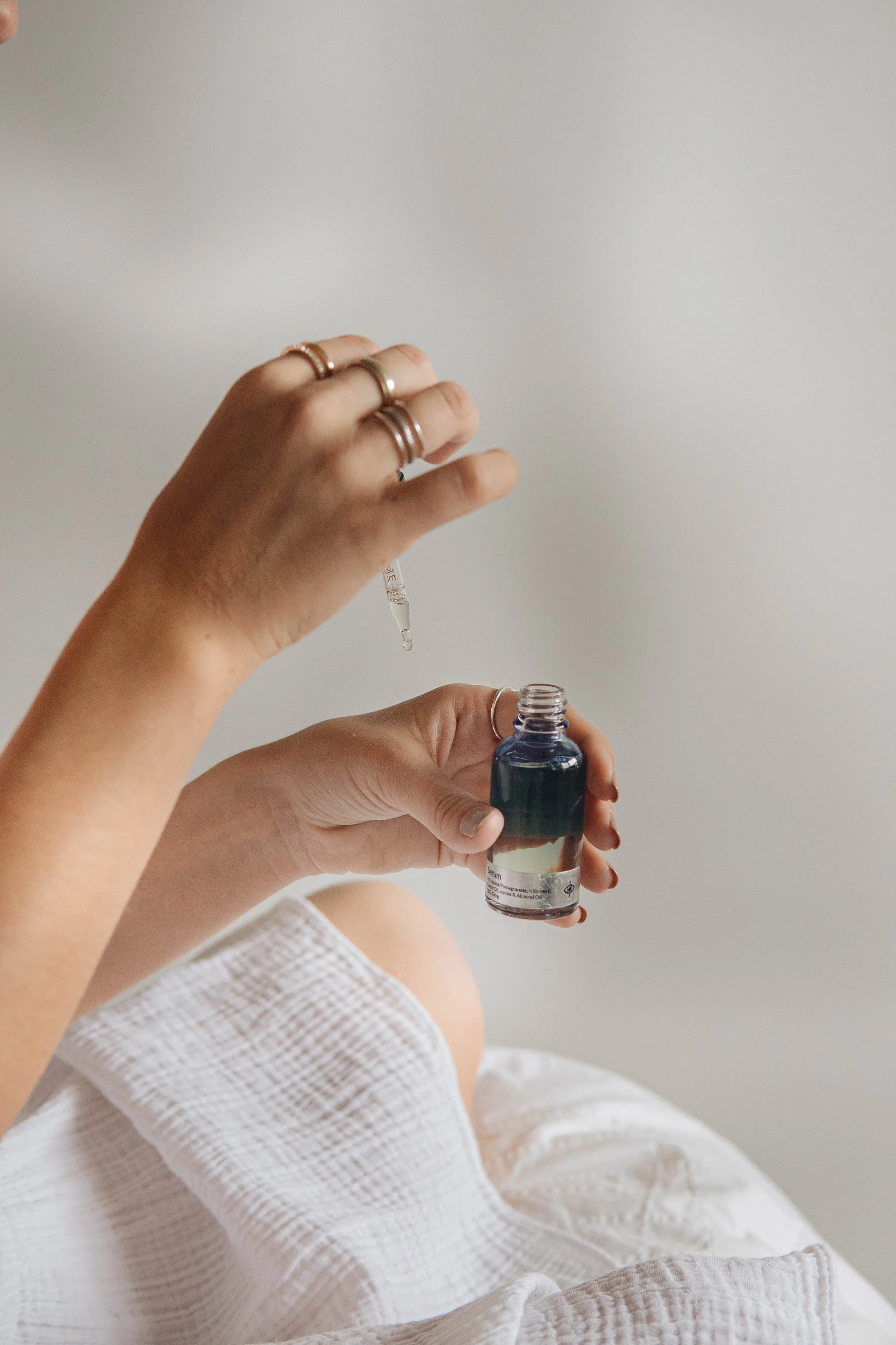Hand holding a small dropper bottle